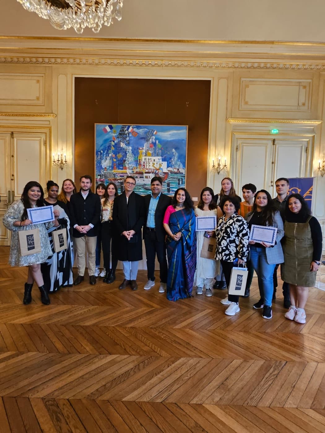 Students holding certificates in a gilded French salon during the immersion programme