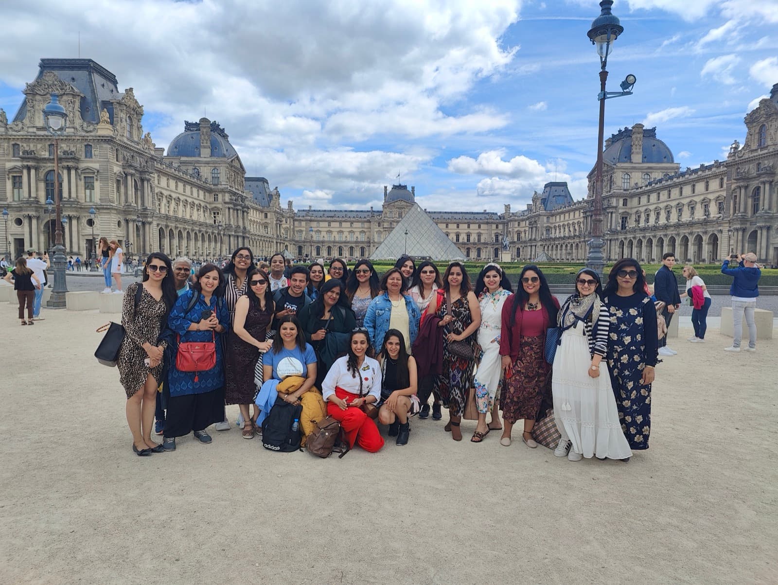 French teachers from India before the glass pyramid in the courtyard of the Louvre, Paris